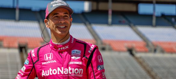 Helio Castroneves standing inside a race track