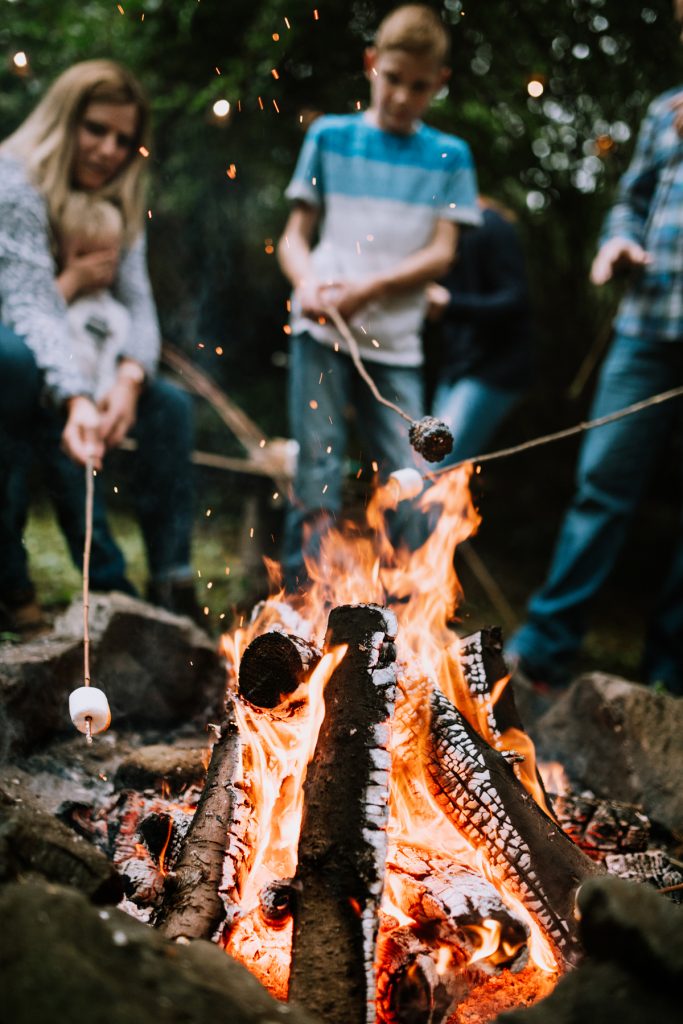 Family around a campfire roasting marshmallows 