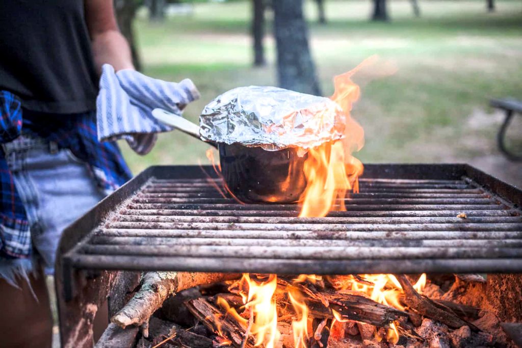 Popcorn in a pan covered in foil on the grill