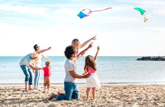 Family on the beach flying kites