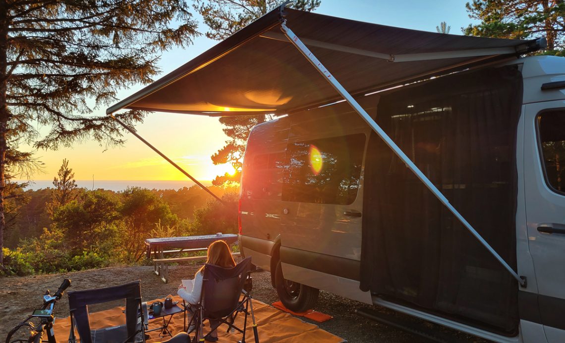 Women sitting next to her RV while watching the sunset